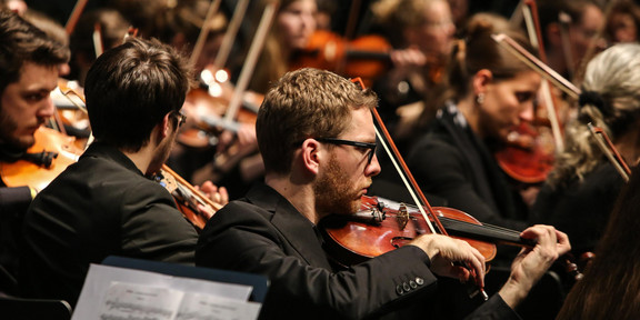 Studentenorchester der TU Dortmund Ein Musiker mit Geige des Studentenorchesters der TU Dortmund im Fokus