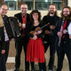 Ein Gruppenfoto des Ensemble für neue Kammermusik. Alle Musiker:innen halten ihre Instrumente im Arm.