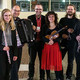 Das Ensemble für Neue Kammermusik Ein Gruppenfoto des Ensemble für neue Kammermusik. Alle Musiker:innen halten ihre Instrumente im Arm.