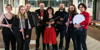 Das Ensemble für Neue Kammermusik Ein Gruppenfoto des Ensemble für neue Kammermusik. Alle Musiker:innen halten ihre Instrumente im Arm.