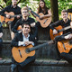 Ein Gruppenfoto des Gitarrenensembles. Die Zehn Musiker:innen halten ihre Gitarren auf dem Schoß.
