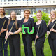 Gruppenbild des Ensembles "TU Flutes", die Musiker*innen halten ihre Flöten in der Hand, die Leiterin hält ein grünes TU-Logo in der Hand.